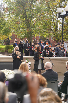 Ifeyinwa Ojukwu, who represents Gretchen Joyce Dater, lays her rose on the wall as the sun shines past the clouds and illuminates the Place of Remembrance.