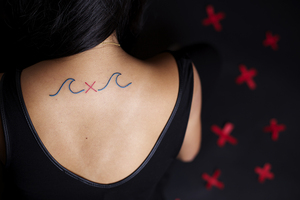 Liza Posner, a junior advertising major, showcases her tattoo of a red 