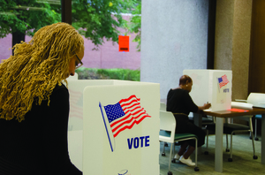 A voter takes to the polls in Bird Library for local elections a year ago. Bird Library will not serve as a voting location on Tuesday, but several other places on and around campus will.