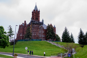 People stop to look at the scaffolding on Crouse College as workers continue to replace masonry and do other improvements to the historic building.