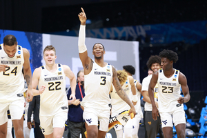 In home games, the WVU basketball team walks onto the court on an old gold and blue carpet.