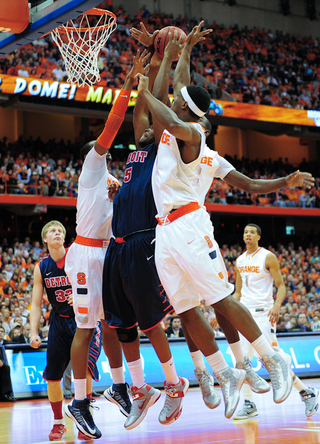 Detroit's Ugochukwu Njoku fights for a rebound amid a clash of Syracuse players.