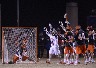 Lamolinara looks on in a split position while Virginia celebrates a goal. 