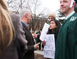 Sierra Messina-Yauchzy, a sophomore mechanical engineering major at SU, confronts a parent of a SUNY-ESF graduate outside of Hendricks Chapel. 