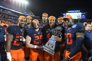 Players pose with the Camping World Bowl trophy. 