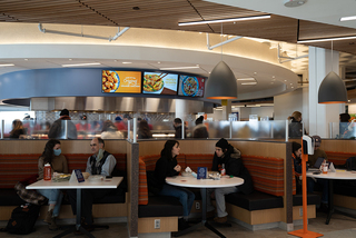 Students eat and chat at Schine's dining area. Schine offers dining options such as Dunkin', Panda Express, CoreLife Eatery and others.