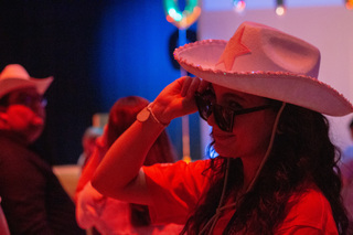 Students dress up in fun hats, sunglasses, tutus, face jewels, and glitter ready to dance the day away. 